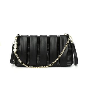 Minimalist black pleated handbag with gold chain and large pearl charms on white background