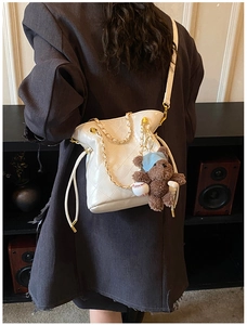 Quilted cream crossbody bag with gold chain and a cute teddy bear charm detail