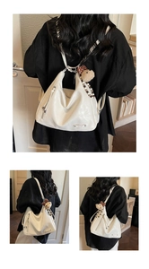 Détail du sac à dos en similicuir blanc avec fermeture éclair et breloque ours mignon