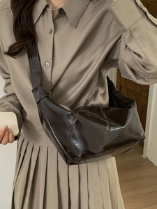 Fashionable dark brown glossy leather saddle bag with wide shoulder strap for women