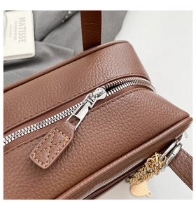 Detail of silver zipper and brown lychee grain leather on elegant commute handbag