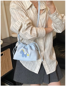 Detail of light blue cloud bag featuring cute horse embroidery and drawstring closure