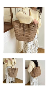 Detail of a brown hollow straw woven tote bag with dark leather straps on a model
