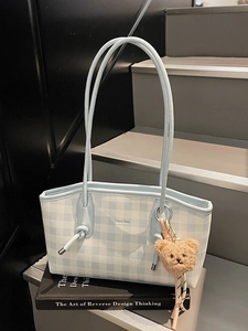 Blue and white checkered large tote bag with bear charm on modern stairs background