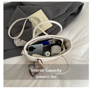 Internal capacity of white leather shoulder bag showing daily essentials and phone