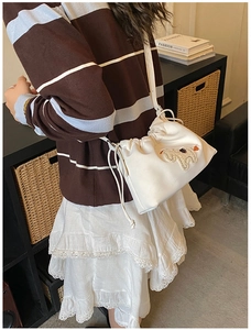 Close-up of white canvas drawstring bag featuring a cute 3D plush sheep embroidery detail