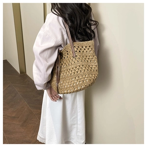 Detail of hand-woven tote bag with hollow diamond pattern and brown leather strap