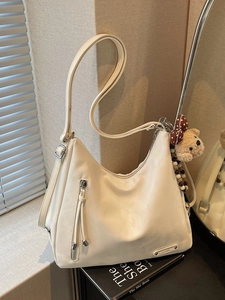 Sac hobo blanc crème en similicuir avec un pendentif ours mignon sur des livres noirs