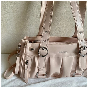 Close-up of pink pleated shoulder bag with metal ring accents and side tassel detail