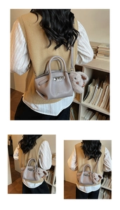 Detail of lychee textured bucket bag featuring metal twist lock and plush bunny charm