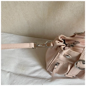 Close-up of pink shoulder bag showing silver hardware buckles and premium stitching detail