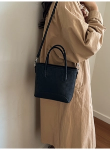 Detail of black matte tote bag showing handle texture and adjustable shoulder strap