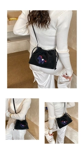 Detail of black drawstring bucket bag with colorful pegasus embroidery and slim strap