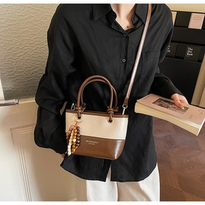 Detailed view of vintage bucket bag featuring contrast leather and decorative wood beads