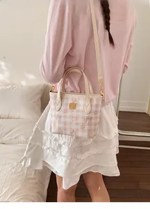 Detail of pink plaid handbag with cute cartoon bear prints and golden metal hardware