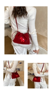 Detailed views of red drawstring bucket bag with horse embroidery and slim shoulder strap