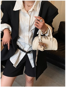Chic cream Boston bag detail with plush bear charm styled with a modern blazer