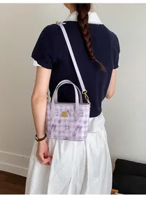 Detail of light purple embossed bucket bag with bow patterns and gold hardware