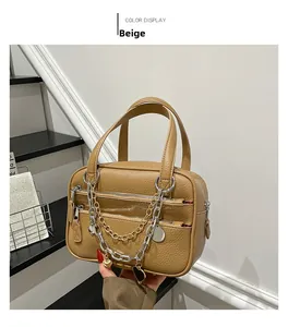 Detailed view of brown lychee grain bag with decorative metal chains and heart charms