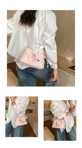 Detail of light pink drawstring crossbody bag with sequined pony embroidery on fabric