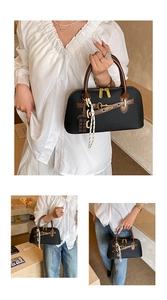 Détail du sac Boston noir rétro avec poignées marron et boucles dorées métalliques