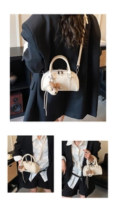 Detail of cream bowling bag with teddy bear charm and adjustable shoulder strap