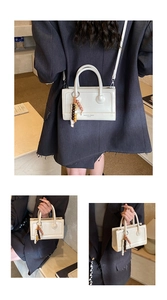 Detail of off-white baguette bag with bead tassel and Fashion & Bags text on leather