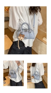 Detail view of lavender Boston bag with plush bear charm and detachable shoulder strap