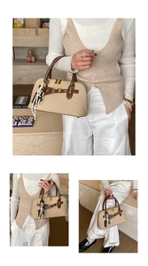 Détail du sac à main beige arrondi avec poignées marron et décoration foulard en soie
