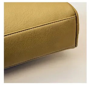 Detail view of thickened base and stitching on yellow pebbled leather Boston bag