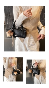 Detail of black bowling handbag with silver hardware and cute bear charm accessory
