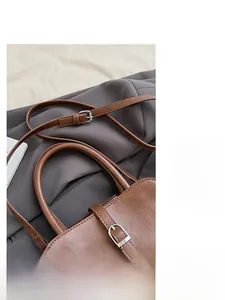 Detail of adjustable brown faux leather strap with metallic buckle on retro handbag