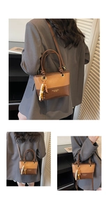 Detail view of vintage bucket bag featuring two-tone brown panels and beaded charm