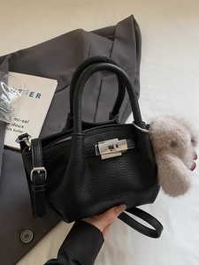Fashionable black pebbled leather crossbody bag with silver lock and plush rabbit charm