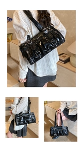 Close-up of glossy black multi-pocket shoulder bag with punk buckles and vintage pleats