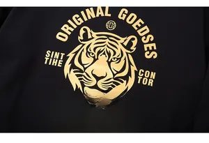 Gros plan détaillé du motif tête de tigre dorée et impression à la feuille d'or sur sweat noir