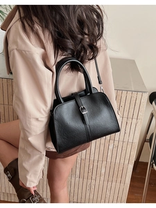 Vue arrière d'un mannequin portant un sac à main vintage en cuir noir avec boucle en métal