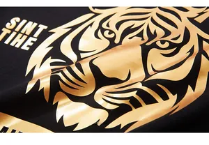 Détail de l'imprimé tigre doré et du lettrage artistique SINT THE sur sweat-shirt en coton noir