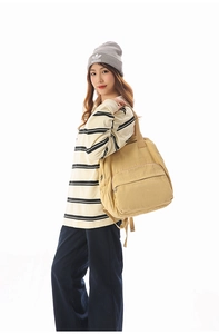 Close-up of khaki corduroy backpack side view showing adjustable strap and side pocket
