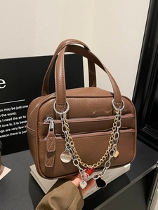 Brown lychee texture leather Boston bag with dual handles and gold heart charm chain