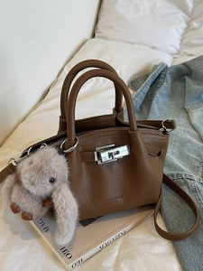 Brown lychee leather pleated shoulder bag with silver turn-lock and plush rabbit charm