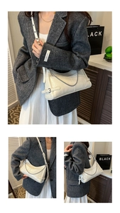 Dettaglio della borsa sottobraccio bianco off-white con catena argento e tracolla