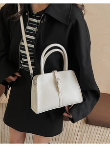 Sac à main trapèze blanc crème avec boucle argentée porté en bandoulière