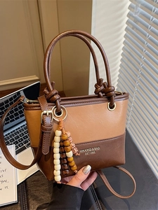 Chic patchwork leather handbag in brown tones with beaded tassel and adjustable strap