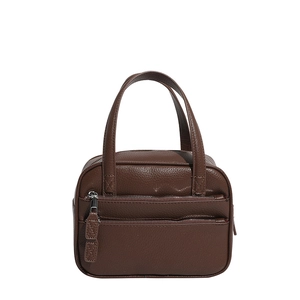 Detail of dark brown leather briefcase featuring dual handles and layered front zipper pockets