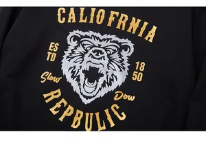 Detail of rhino rhinestone and gold foil lettering pattern on a black hoodie