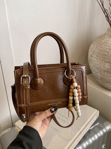 Vintage brown leather box bag with wooden bead charm and adjustable crossbody strap