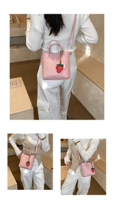 Dettagli della borsa a secchiello rosa in ecopelle con ciondolo a fragola carino