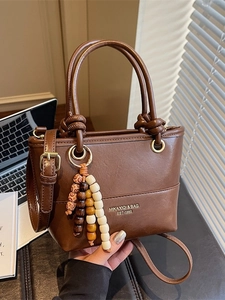 Brown vintage faux leather handbag with wooden bead charm and knotted top handle