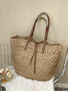 Large hand-woven straw tote bag with brown leather handles and inner lining for beach holidays